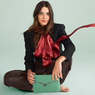 Botkier model holding valentina flat crossbody in clover