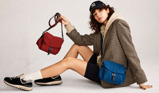 Botkier homepage hero image on model baxter crossbody in malbec and teal
