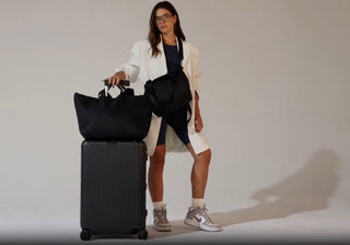 Teaser video of model walking with Carlisle Tote on suitcase